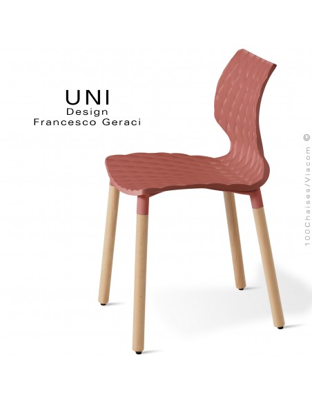 Chaise UNI, piétement bois de hêtre rond, vernis châtaignier. Assise coque plastique effet matelassé couleur rouge corail.